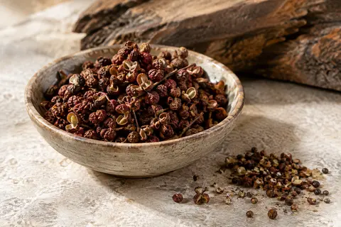Baies entières de Sichuan rouge-brun disposées dans une petite coupelle en céramique